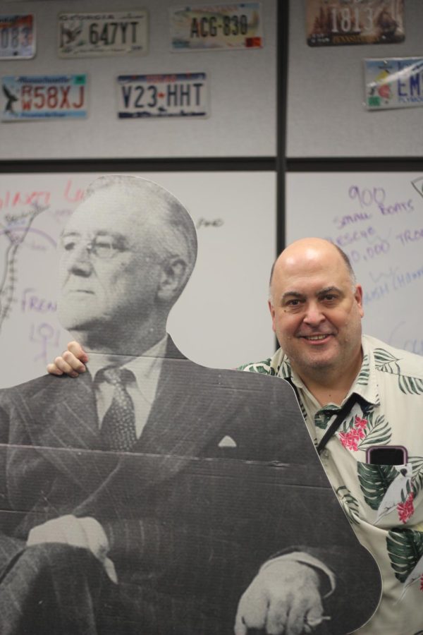 Mr. Crisp stands in his classroom sporting a Hawaiian shirt, along with his massive cardboard cutout of former President Franklin D. Roosevelt. 