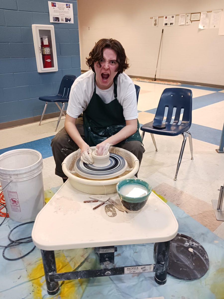 Danny Reed (Senior) at the pottery wheel next to his stand  at art night
