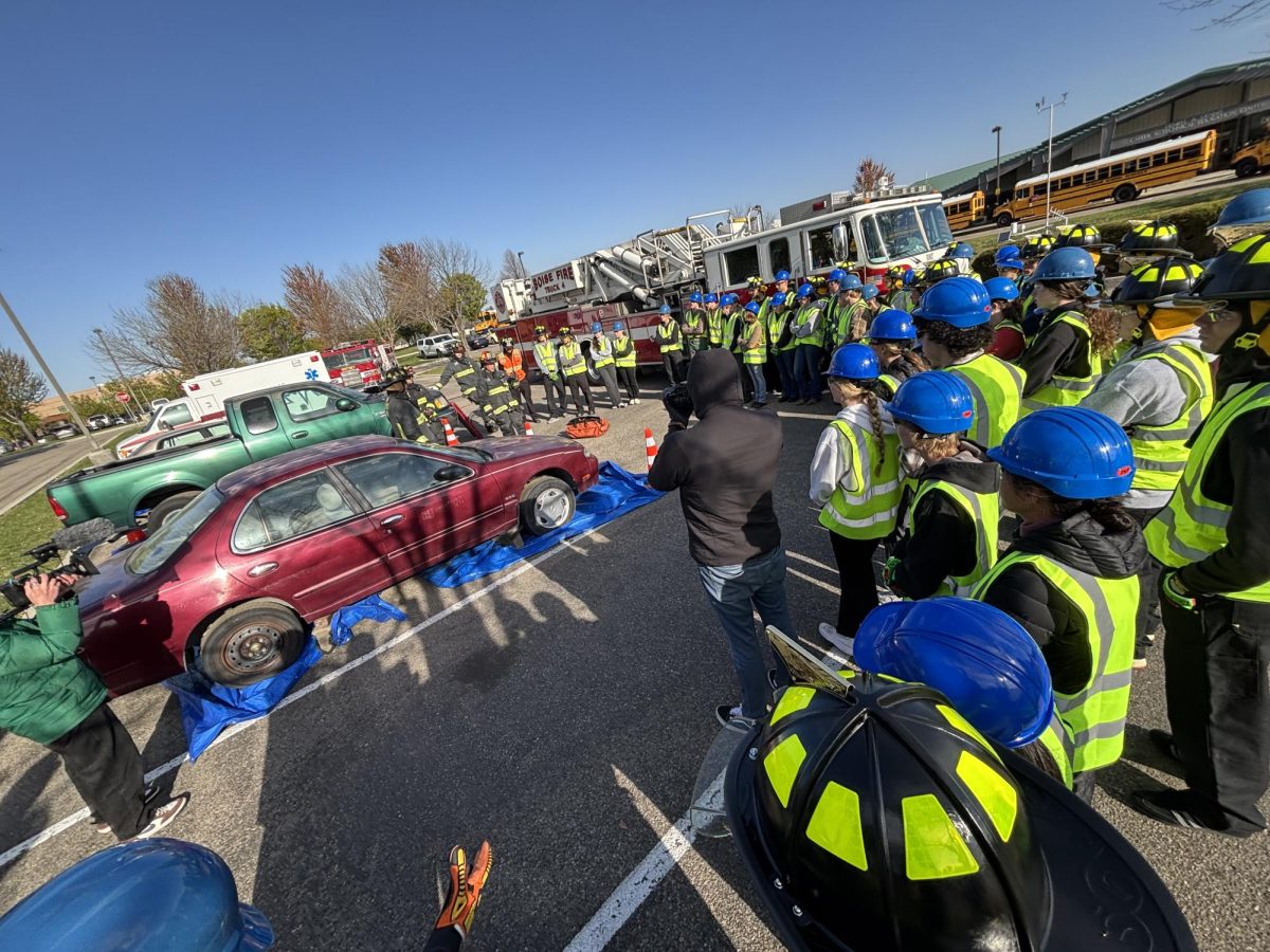 The firefighters talking to the students about the tools they were using.