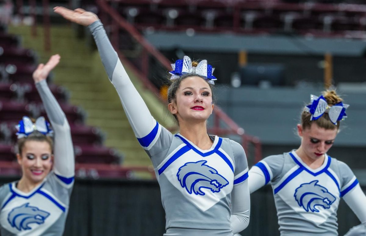 Paige Aslett (Sr.) cheering at a competition. 